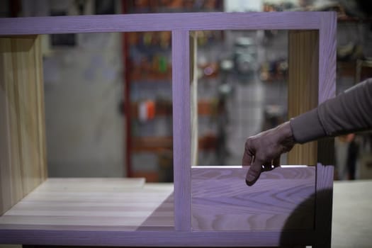 Manufacture of furniture. Guy holds board. Joinery. Work with wood.