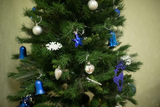 Blue decorations on Christmas tree. Christmas tree toys of blue color. Christmas tree in apartment. Christmas Holiday Details.