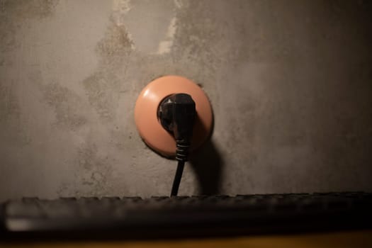 Plug in socket. Electricity at home. Black cable. Wires in apartment.
