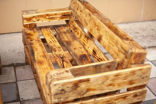 Bench made of boards. Craft furniture. Interior details. Cheap solutions. Sofa made of raw boards.