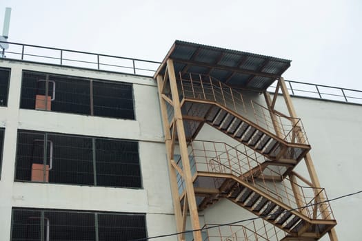 Stairs outside building. Fire escape on wall. Building from courtyard. Back-up.