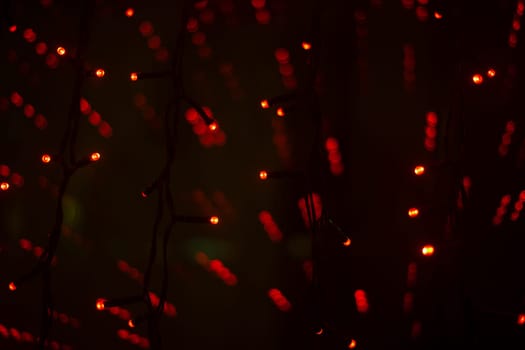 Red garlands in interior. Lights in dark. Room details. Light on window. Red lights shine.