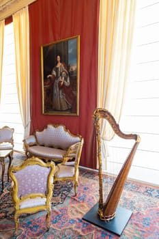 Venaria Reale, Italy - February 2023: luxury interior, old Royal Palace. Perspective with harp, window and baroque decoration.