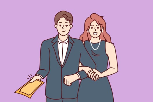 Elegant man and woman in formal evening wear for event holding hands demonstrating invitation to ceremony. Family couple in tuxedo and dress for attending theater or awards ceremony for celebrity