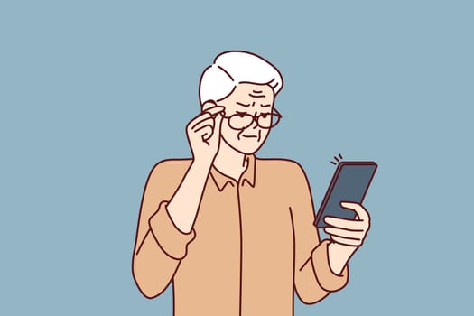 Elderly man with poor eyesight squint looking at screen of mobile phone to read SMS. Grandpa is having vision problems due to cataracts in eyes and needs help of ophthalmologist doctor