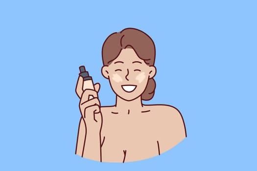 Woman with liquid foundation smiles as she puts on makeup to hide skin imperfections. Positive girl demonstrates new foundation recommending use of high-quality cosmetics for skin care