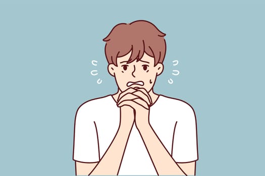 Excited man makes gesture of praying asking lord for help in solving problems that have arisen. Frightened guy praying and begging god to help him recover from disease or be saved for sinful act