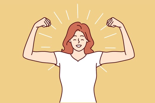 Woman shows biceps and smiles standing in strongman pose to demonstrate self-confidence and readiness for new achievements. Girl boasts biceps after going to fitness room and training with trainer
