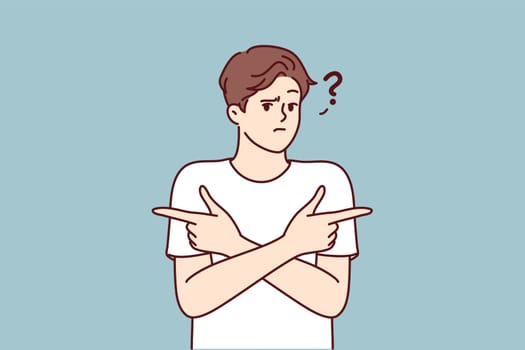 Puzzled man pointing fingers in different directions doubtful trying to accept difficult decision with unknown consequences. Puzzled guy is wondering what to make choice between two options