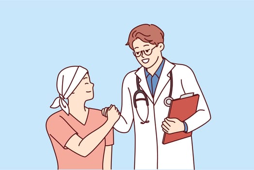 Doctor shakes hands with little cancer patient undergoing chemotherapy to fight cancer. Teenage boy with cancer lost his hair due to radiation exposure and needs support of clinic staff and parents