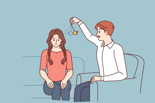 Man psychotherapist hypnotizes woman patient using pendulum to solve psychological problems in subconscious. Guy hypnotizes girl to take advantage unconscious state or remove information from memory