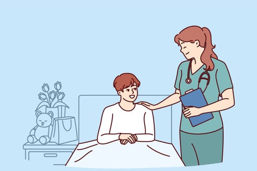 Woman doctor near boy lying on bed in hospital after complications of chronic disease. Doctor pediatrician supports teenager undergoing rehabilitation in hospital after complex operation
