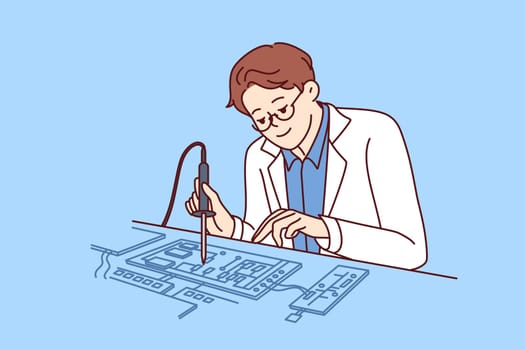 Man engineer uses soldering iron to repair computer board or invent new technology. Guy working as engineer in technology laboratory repairs electronic components from modern digital equipment