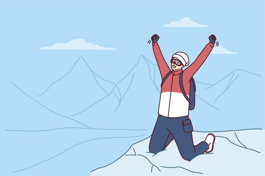 Inspired traveler man stands on mountaintop rejoicing at successful climbing Everest peak or new world record. Male tourist raises hands as sign of victory after climbing on hard to reach place