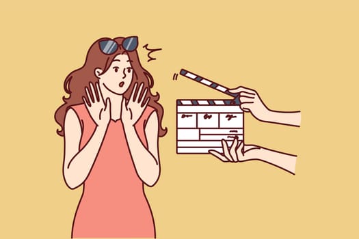 Woman movie star is embarrassed sees clapboard passing casting call for role in popular series or tv show. Movie star girl waving hands, not wanting to film or answer questions from reporters
