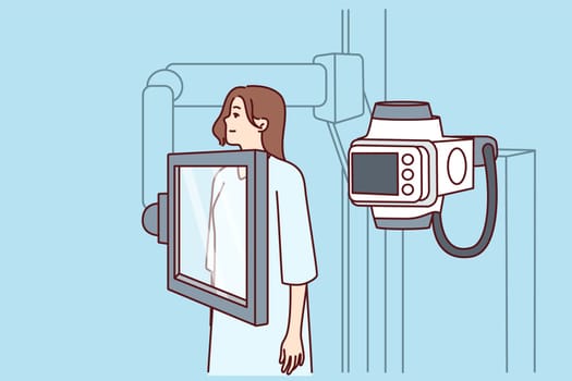 Woman suffering from cancer stands near x-ray machine making medical examination for diagnosing oncological disease. Girl during mammogram for early detection of breast cancer undergoes radiography
