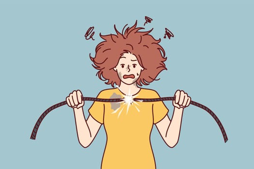 Woman with damaged electrical wire suffers from electric shock and power failure. Funny girl with disheveled hair was shocked after feeling shock from electricity and trying to fix wiring