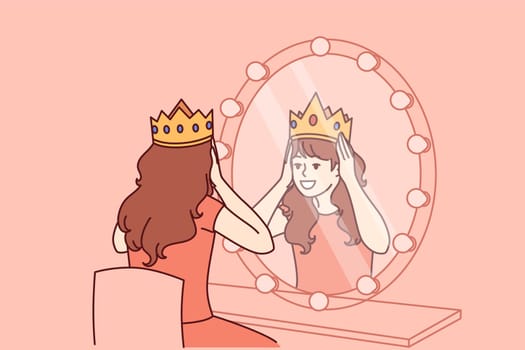 Little actress tries on crown sitting in dressing room with mirror and dreams of playing role of princess on theater stage. Teenage girl puts princess crown on head dreaming of living among kings
