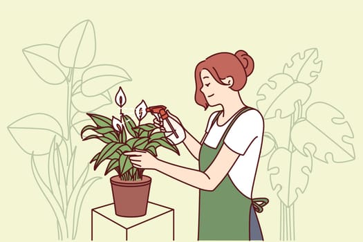 Woman gardener from greenhouse takes care of house plants by spraying leaves with fertilizer to get rid of termites. Florist girl works in greenhouse and breeds home plants for sale in own store