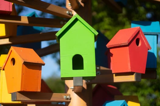 Houses for birds. Colored wooden houses. An element in the park. Art object for animals. Bird care.