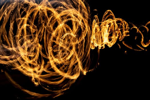 Flames on long hatchet. Traces of fire in dark. Flames spread chaotically in space.