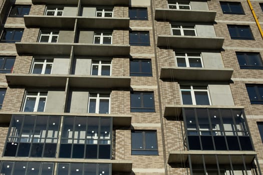 Building with windows in city. High house. Many floors in building. Modern architecture. Details of urban backlogs.