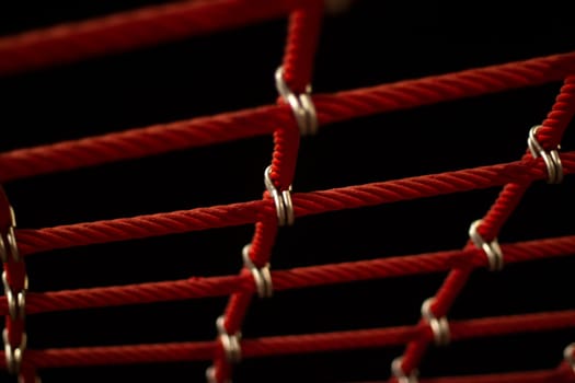 Ropes in the playground. Climbing net, shot close-up. Ropes fastened with links. Rope texture shot at night in street lighting.