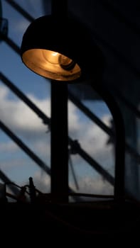 Table lamp in room. Light on table. Old type incandescent lamp. Interior details.