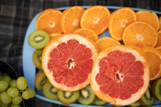 Sliced fruit. Oranges and kiwifruit. Picnic details. Healthy food. Juicy fruit.
