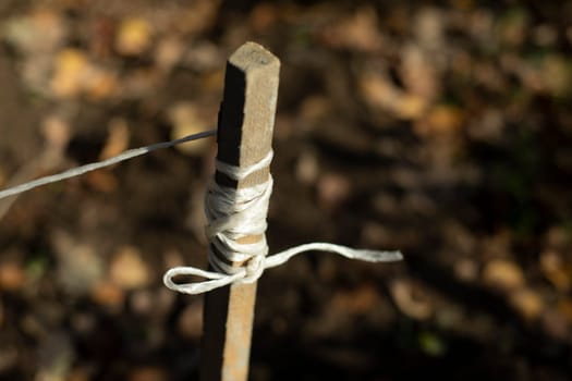 Rope on stick. Ground marking. Rope wound on board. Earth measurement by filament. Peg driven into ground.