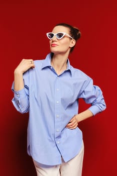 Studio portrait of beautiful woman in blue cotton shirt and sunglasses