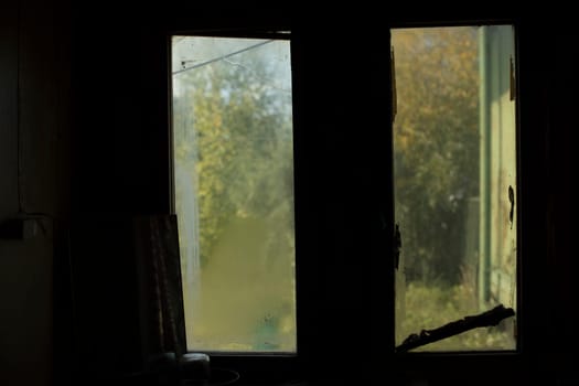 Dark window in room. Old window in interior. Details of room. Cloudy glass.