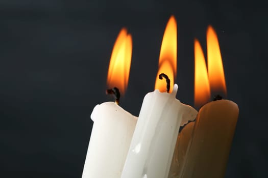 sacred candles in dark on black background
