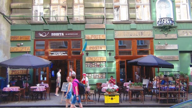 LVIV, Ukraine - Aug 12, 2015. People sits in front of Post Office pub located on the old town of Lviv. People relaxing in a popular bar "Post Office"" on Drukarska Street."