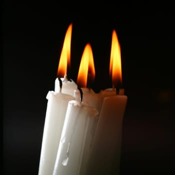 sacred candles in dark on black background