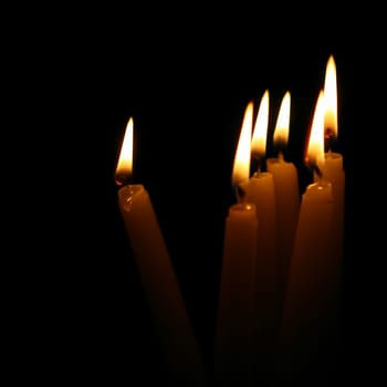 sacred candles in dark on black background