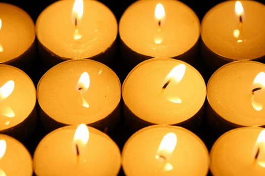 sacred candles in dark on black background