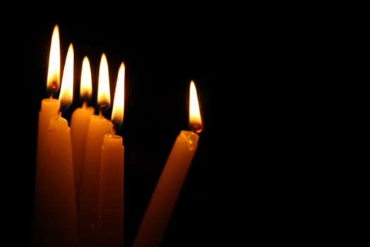 sacred candles in dark on black background