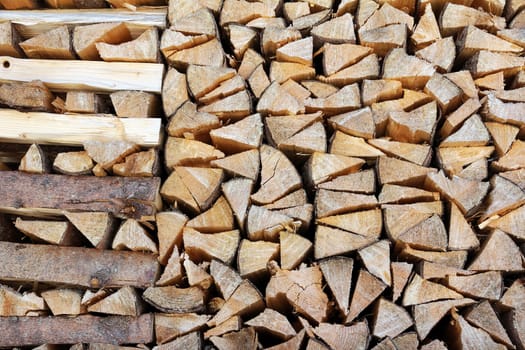 Stacked firewood. Logs on a wall