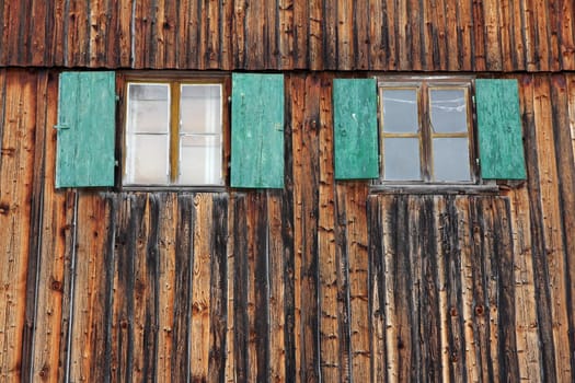 Window with shutters on an old farm with wooden wall