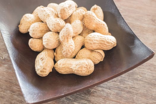 Salted peanuts on wooden bow, stock photo