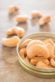 Cashew nut roast salt on weathered wooden table, stock photo