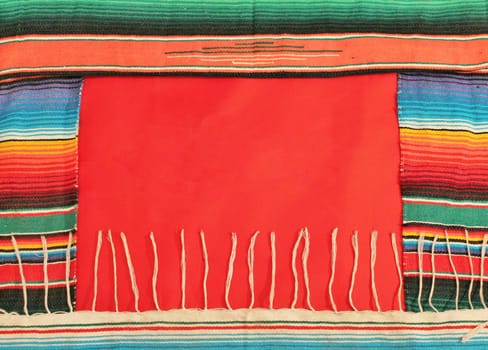 Traditional Mexican fiesta poncho rug in bright colors with sombrero background with copy space