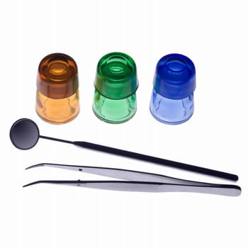 Dental tools and flasks on white background