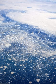 An aerial view of a melting glacier in the ocean.