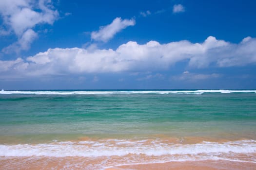 Peaceful beach scene with ocean and blue sky