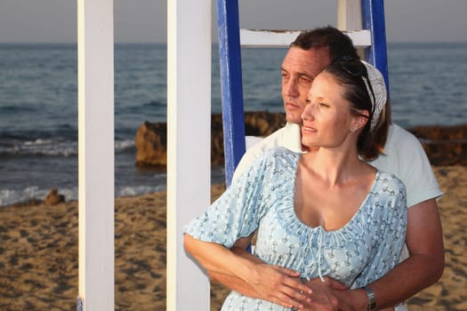 beautiful happy couple enjoying sunset on the beach