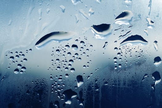 Large and fine water drops on glass background