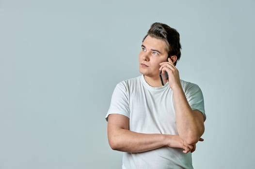 a man on a gray background is talking on the phone. High quality photo