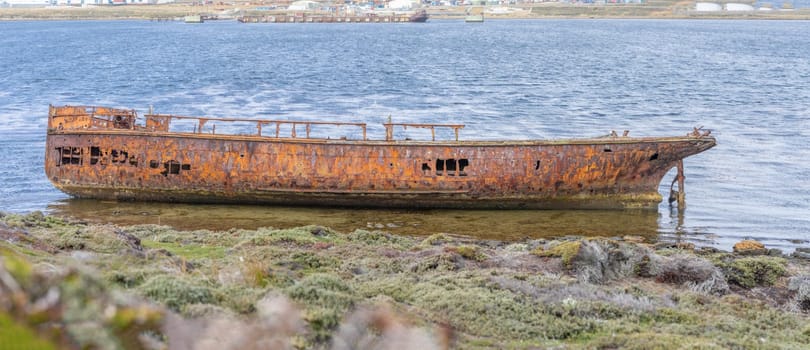 An old whaler wreck in Whalebone Cove off Stanley in the Falkland Islands. Stanley in the background